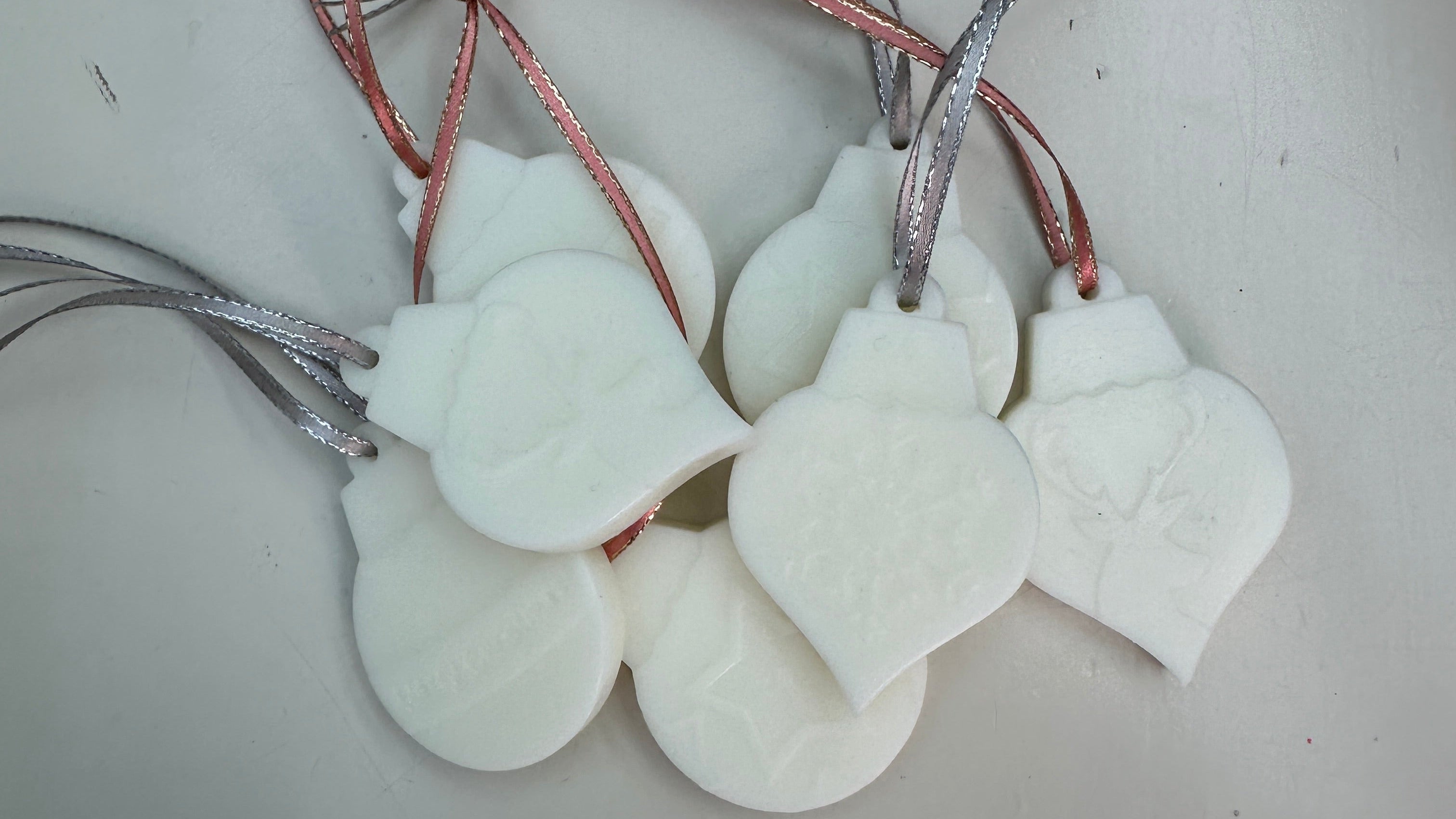 White wax scented decorations in the shape of Christmas baubles on shiny ribbon