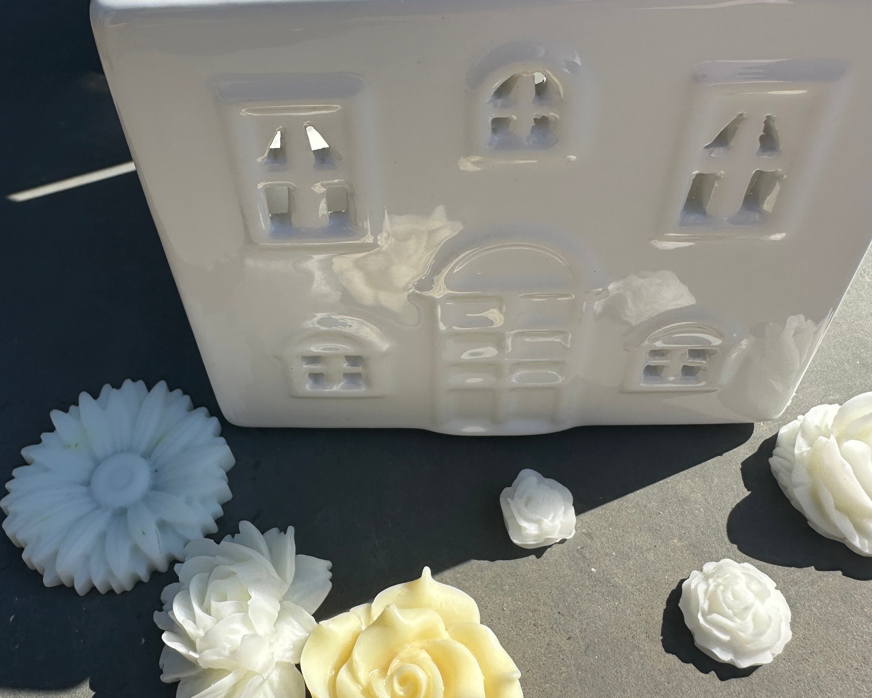 White ceramic house shaped wax burner with floral shaped wax melts